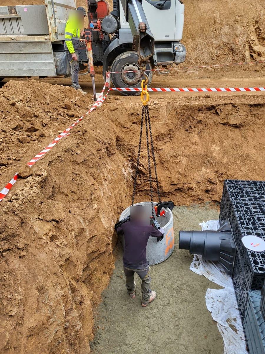 Pose d'un regard béton au camion-grue sur un chantier d'assainissement SOTTEC