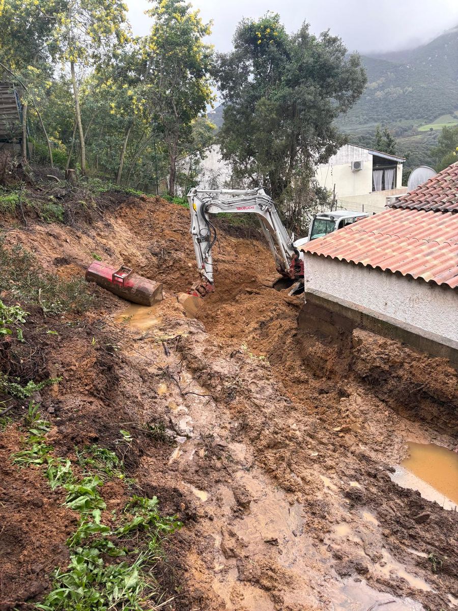 Terrassement derrière une maison : la pelle prépare le terrain